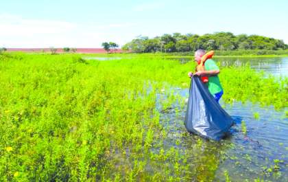 Pintor aluga barco para recolher lixo no rio Tietê em missão solitária