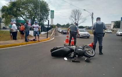Mulher fica ferida ao ter Biz atingida por carro em rotatória