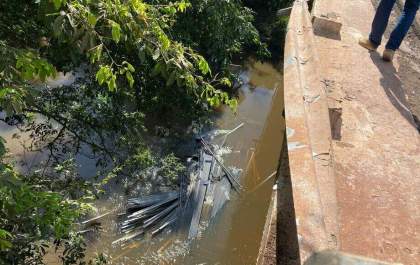 Motorista perde controle e semirreboque com ferro cai em rio