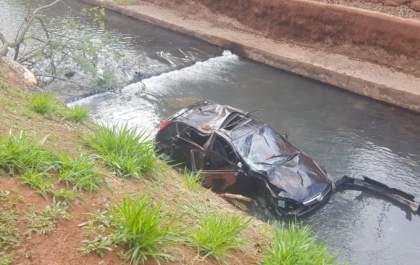 Motorista bate em árvore, veículo capota e cai dentro de córrego
