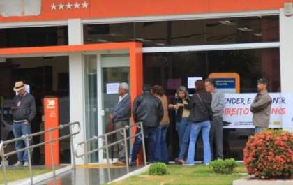 Clientes enfrentam chuva na espera por abertura de agências