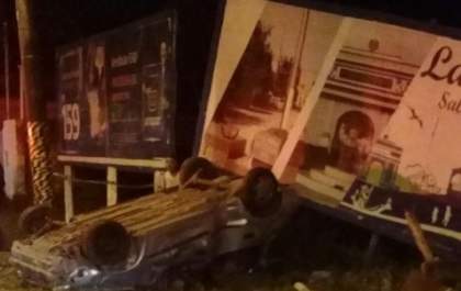 Carro capota, bate em outdoor e três pessoas ficam feridas